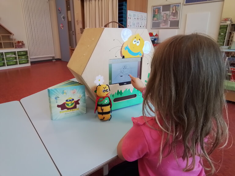 Das Bild zeigt die Medienpädagogik Weiterbildung in der Praxis: Ein Kind lernt den achtsamen Umgang mit Medien an der Medienstarter Box.